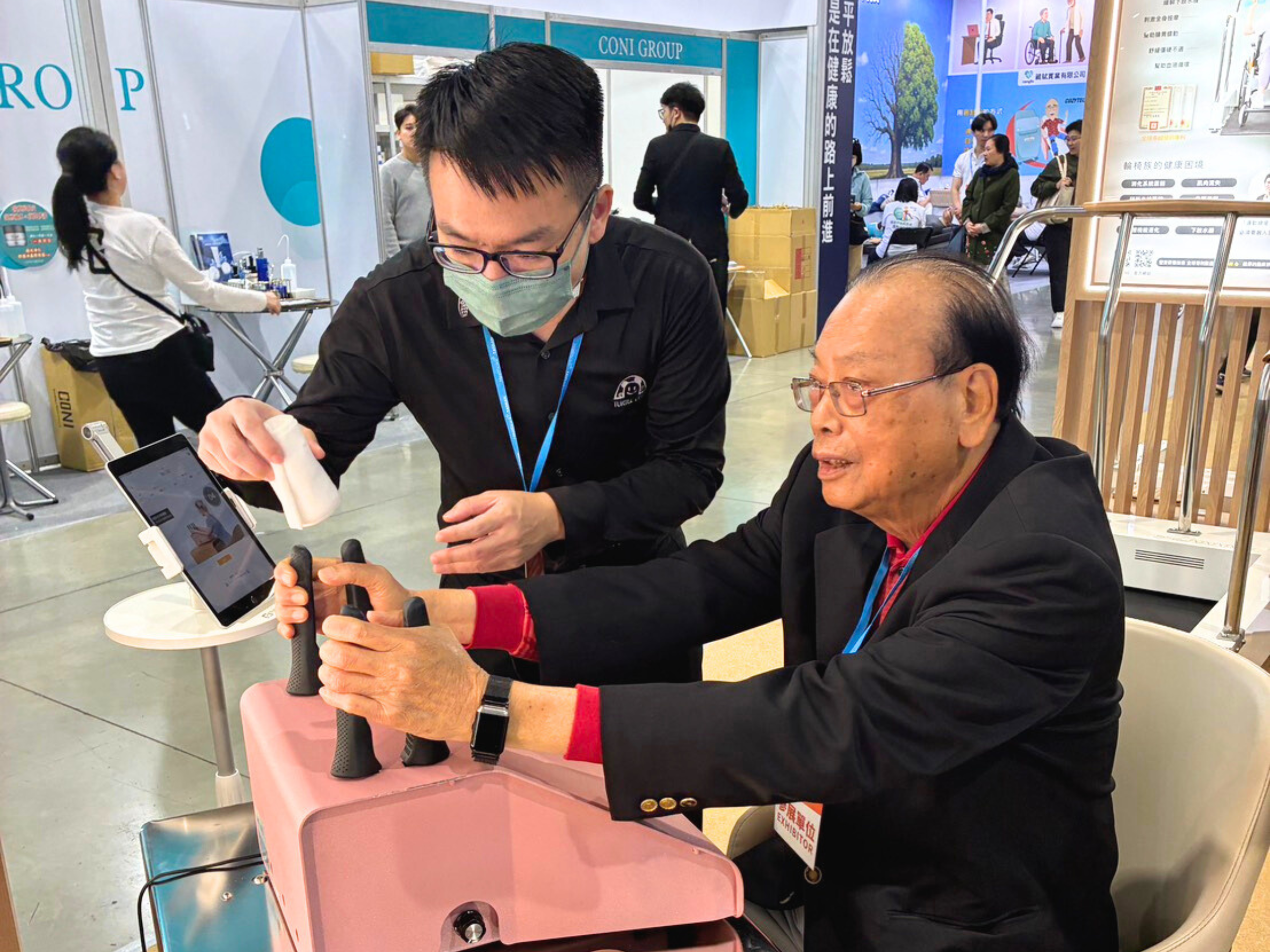 特多勁展位專業顧問為訪客介紹 AI 智慧銀髮健身系統操作