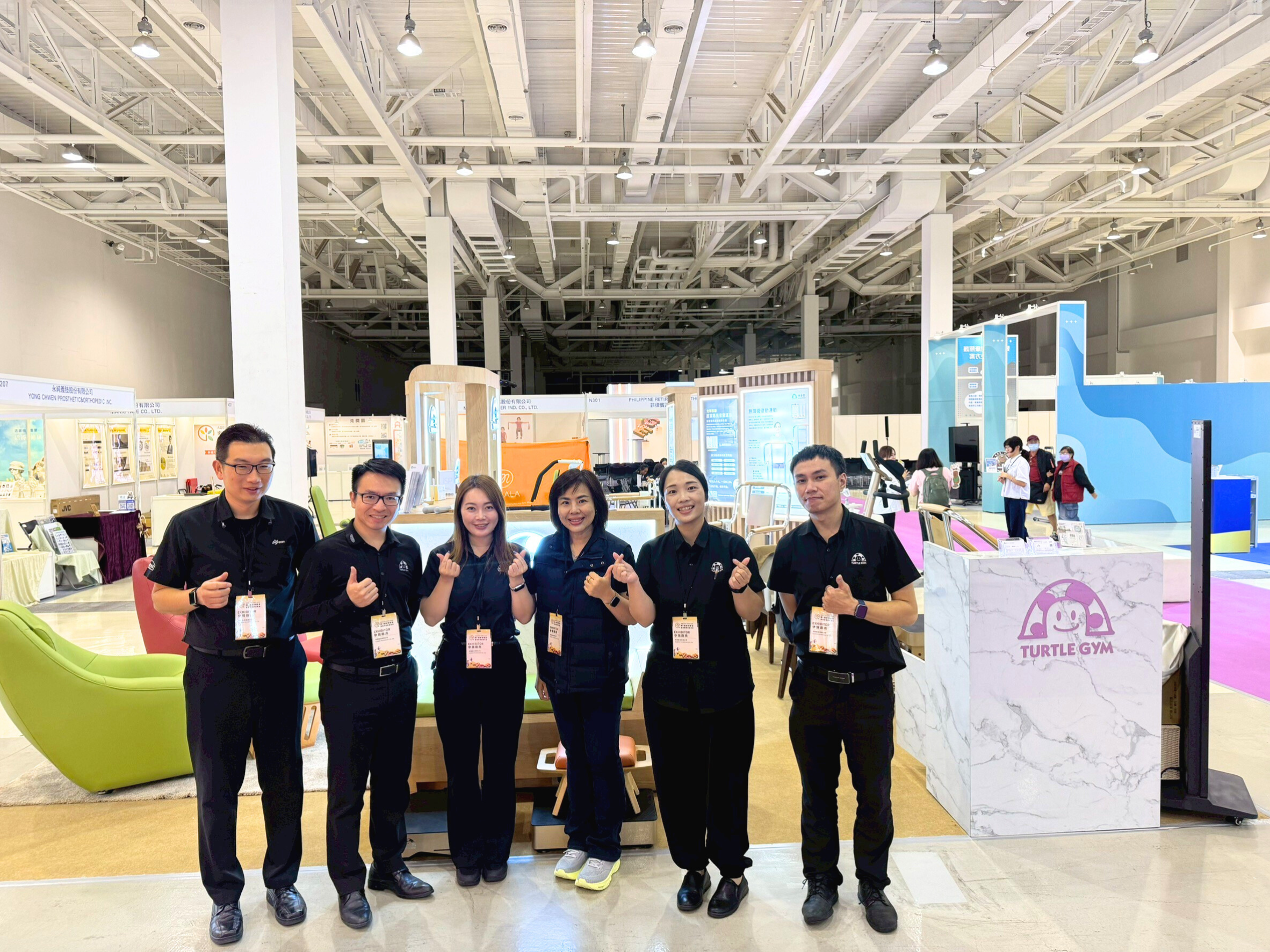 高雄樂無齡博覽會展位，特多勁專業團隊合影留念，AI 智慧銀髮健身系統