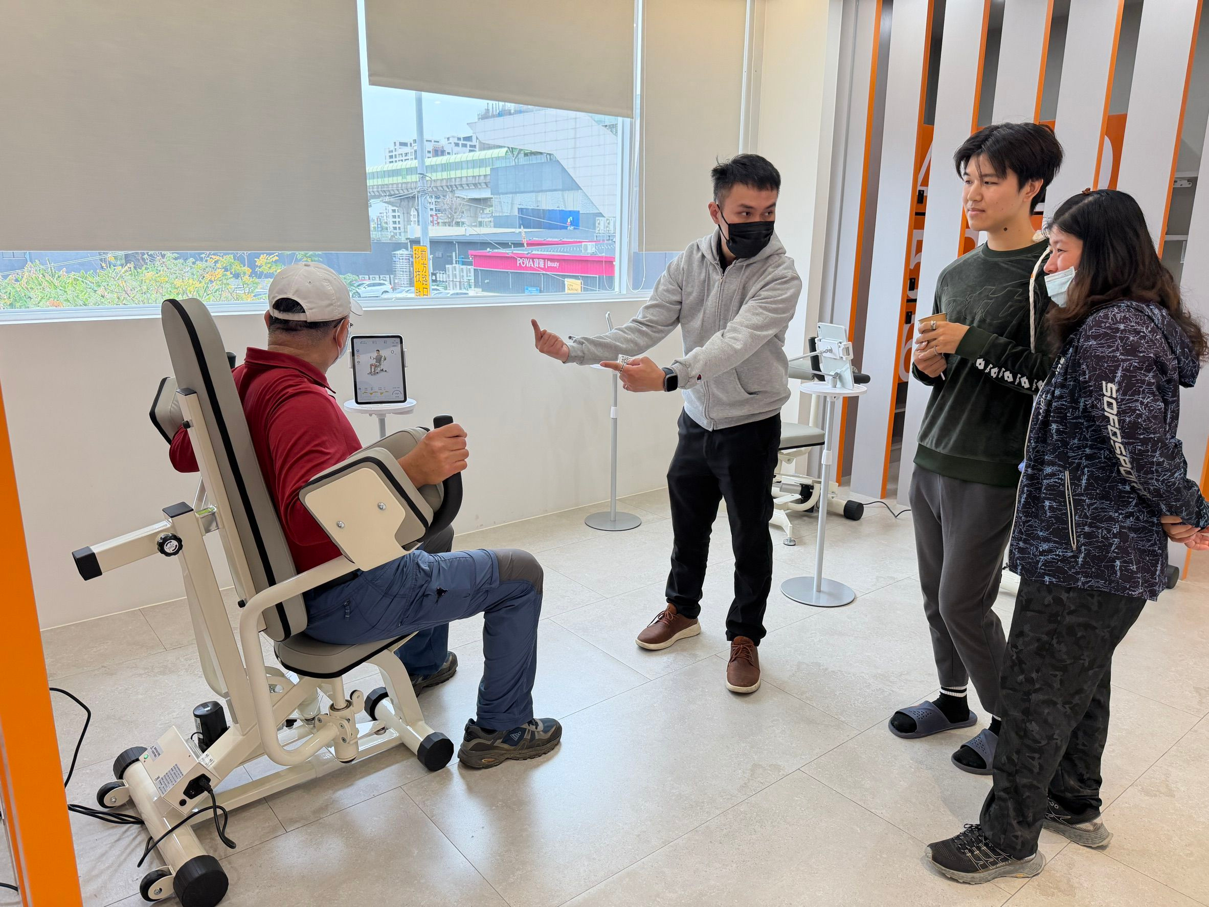 全能家同仁與物理治療師正引導民眾使用智慧版等速肌力訓練設備